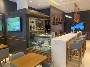 een restaurant met een bar met tafels en stoelen bij Hotel Centro Europeu in Curitiba