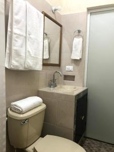 a bathroom with a toilet and a sink and towels at Estancia Buen Dia in Ciudad Valles