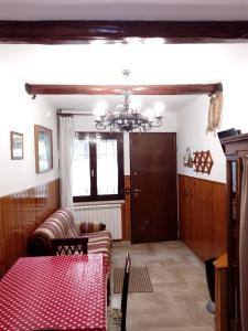 a living room with a table and a chandelier at Appartamentino Le Stelle in Roccaraso