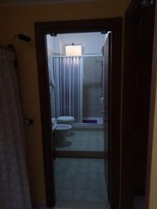 e bagno con doccia e servizi igienici attraverso una porta. di A CASA MIA a San Giorgio Ionico