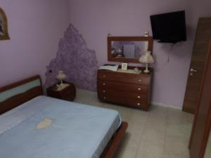 ein Schlafzimmer mit einem Bett, einem Spiegel und einer Kommode in der Unterkunft A CASA MIA in San Giorgio Ionico