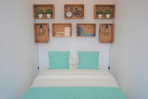 Schlafzimmer mit einem Bett mit blauen Kissen und Holzschränken in der Unterkunft Feeling Chiado 29 in Lissabon