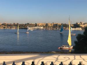 a group of sailboats on a large river with buildings at White House Apartments in Luxor