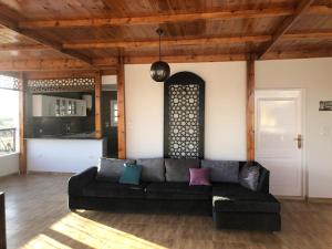 a living room with a black couch and a kitchen at White House Apartments in Luxor