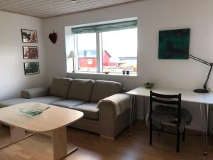 uma sala de estar com um sofá e uma mesa em Light & spacious home em Tórshavn