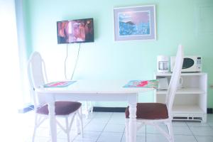 a white table and two chairs in a kitchen at Clearwater Studio @ Sandcastles in Ocho Rios