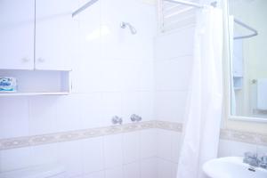 a bathroom with a white shower curtain and a sink at Clearwater Studio @ Sandcastles in Ocho Rios