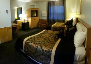 una camera d'albergo con due letti e una televisione di Travellers Motel a Stratford