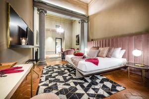 una camera con un letto bianco e un tappeto di Palazzo Bianca Cappello Residenza d'Epoca a Firenze