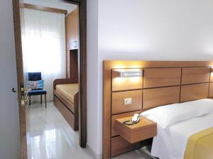 sypialnia z łóżkiem z drewnianym zagłówkiem w obiekcie Villaggio Turistico La Mantinera - Hotel w mieście Praia a Mare