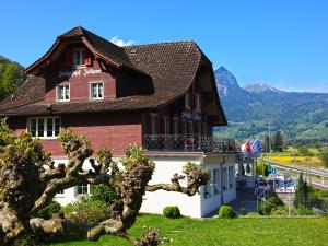 ein Haus in den Bergen mit einem Baum in der Unterkunft Landgasthof Zollhaus in Sachseln