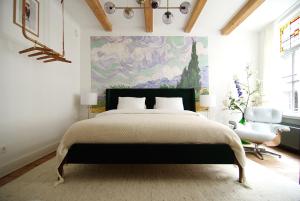 ein Schlafzimmer mit einem großen Bett und einem Gemälde an der Wand in der Unterkunft The Mallory in Amsterdam