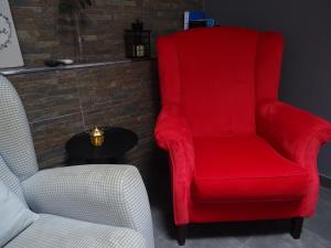 a red chair sitting next to a chair and a table at Apartment My Home in Sesimbra