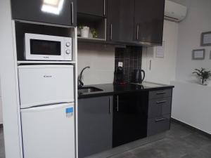 uma cozinha com uma geladeira branca e um micro-ondas em Apartment My Home em Sesimbra