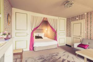 - une chambre dotée d'un lit avec des rideaux roses dans l'établissement La Maison de la Liberté Alexandra David-Néel, à Poitiers