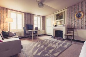 a living room with a fireplace and a table and chairs at La Maison de la Liberté Alexandra David-Néel in Poitiers