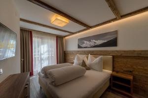 sypialnia z łóżkiem i drewnianą ścianą w obiekcie The Lodge by Regina w Solden