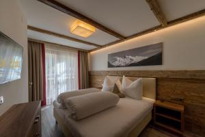 a bedroom with a bed with a wooden wall at Regina's Alpenlodge in Sölden