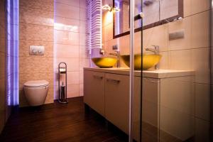 a bathroom with two sinks and a toilet at Dream Aparts - Lofty Scheiblera in Łódź +15 photos