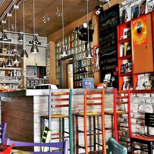 un bar avec des chaises colorées dans un restaurant dans l'établissement Varad INN, à Novi Sad