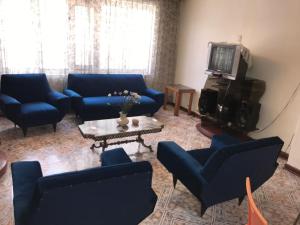 sala de estar con sofás azules y TV en Posada Canela, en Cusco