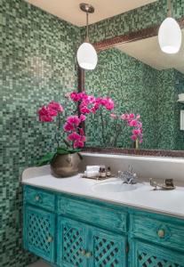 a bathroom with a sink with pink flowers in a vase at Petit Ermitage in Los Angeles