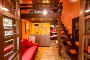 a living room with a red couch in a tiny house at Chalé Rural em Canela in Canela