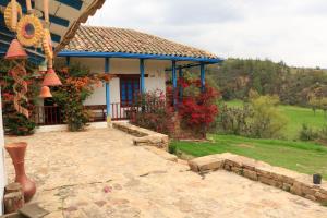 a house with a porch with flowers in front of it at Casa Campestre SUANOGA in Pesca