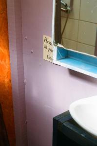 un baño con espejo y un letrero en la puerta del baño en Casa Gaia Cabo Polonio, en Cabo Polonio