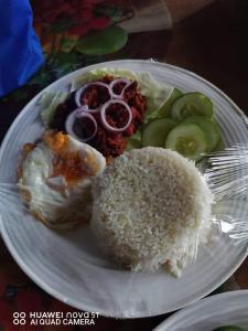 ein weißer Teller mit Reis und Gemüse in der Unterkunft home stay rizalina in Batuan
