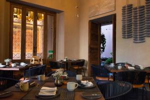 uma sala de jantar com mesas e cadeiras e uma janela em Casa Santiago Hotel Boutique em Querétaro