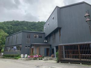 湯澤的住宿－趙酒店，前面有门的黑色建筑