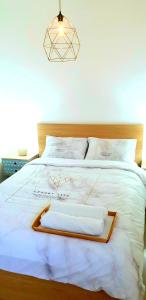 uma cama branca com uma cabeceira em madeira e almofadas brancas em Amazing Modern Room 4 Min From The Tram em Jerusalém