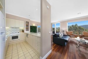 a kitchen and living room with a couch and a table at 2 Bedroom Villa @ Oaks Cypress Lakes Resort in Pokolbin