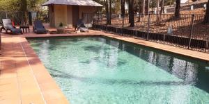 una piscina con agua verde en un patio en 2 Bedroom Villa @ Oaks Cypress Lakes Resort, en Pokolbin