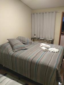 um quarto com uma cama com duas toalhas em Meu cantinho em Serra Negra