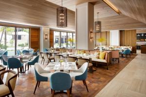 a dining room with tables and chairs at Halepuna Waikiki by Halekulani in Honolulu