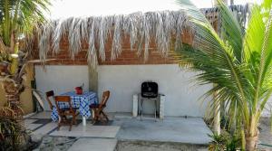 a patio with a table and chairs and a grill at La Casa de Jessy in Máncora