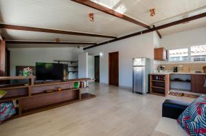 a large living room with a couch and a refrigerator at Condominio Luna Rossa in Morro de São Paulo