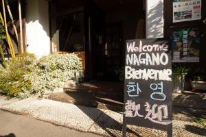 un cartel en frente de un edificio que dice marmita bennett de bienvenida en Umeoka Ryokan, en Nagano