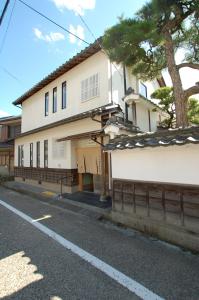 um edifício branco ao lado de uma rua em 三上勘兵衛本店 Mikami Kanbe Honten em Miyazu