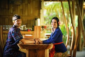 Ein Mann und eine Frau sitzen an einem Tisch in der Unterkunft Ubud Art Resort in Ubud