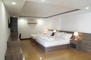 a bedroom with a large white bed and a television at Apple Hotel Three - near PNH airport in Phnom Penh