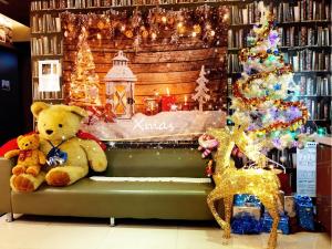 two teddy bears sitting on a bench next to a christmas display at Morwing Hotel Fairytale in Taipei