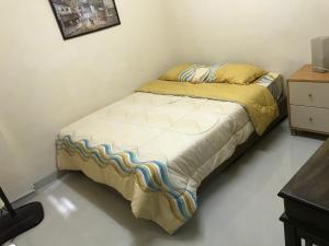 a small bed in a room with a bedspread at Subang Ville Ehsan Apartment in Kampong Baharu Sungai Way