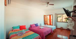 een slaapkamer met 2 bedden en een plafondventilator bij Itza La Veleta Tulum in Tulum