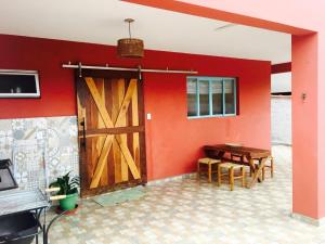 a room with a red wall with a wooden door at Aconchego e conforto em Joanópolis in Joanópolis