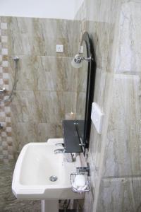 bagno con lavandino e specchio a parete di White Villa Koggala a Habaraduwa Central