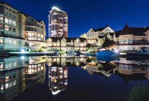 a city with buildings and a reflection in the water at Kelowna Discovery in Kelowna