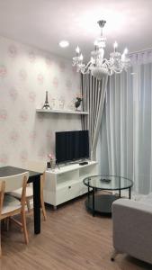 un soggiorno con tv e tavolo di The courtyard khaoyai by Tom a Mu Si